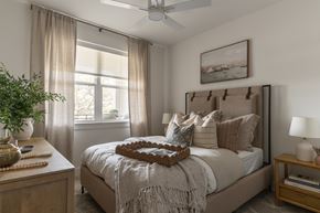 Austin apartment for rent - A bedroom with a large bed and a window with curtains.